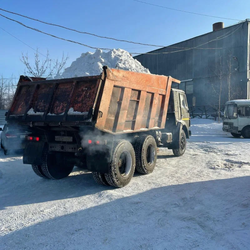 Самосвал КамАЗ вывозит собранный снег